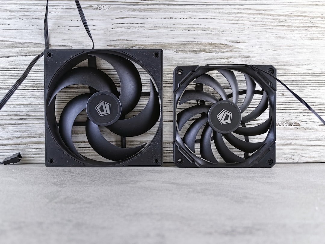 A couple of black fans sitting on top of a table