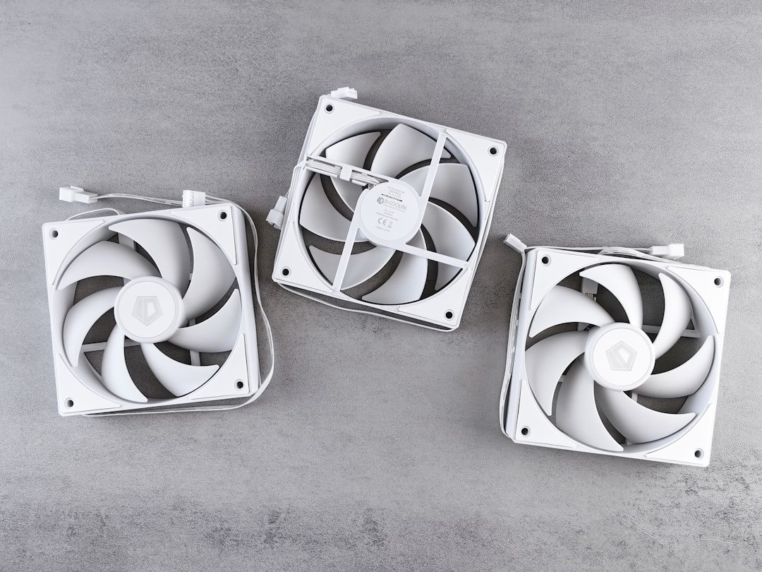 Three white computer fans arranged on a gray surface