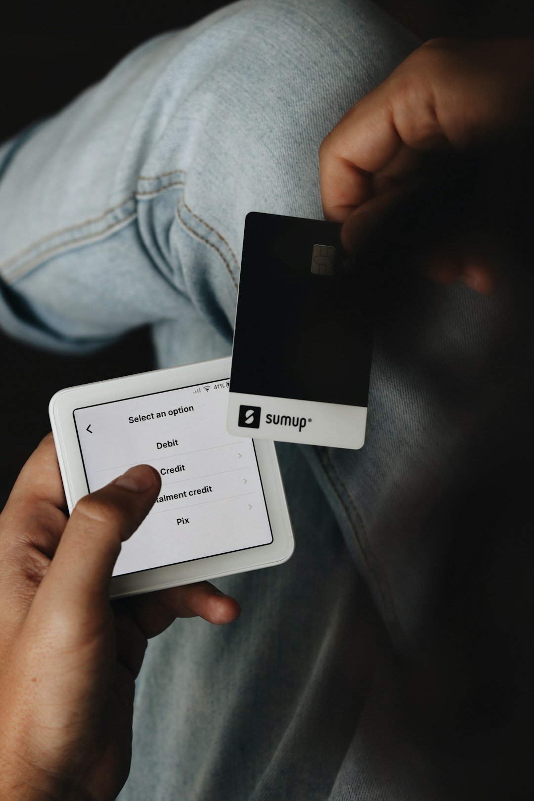 A person holding a tablet and a credit card