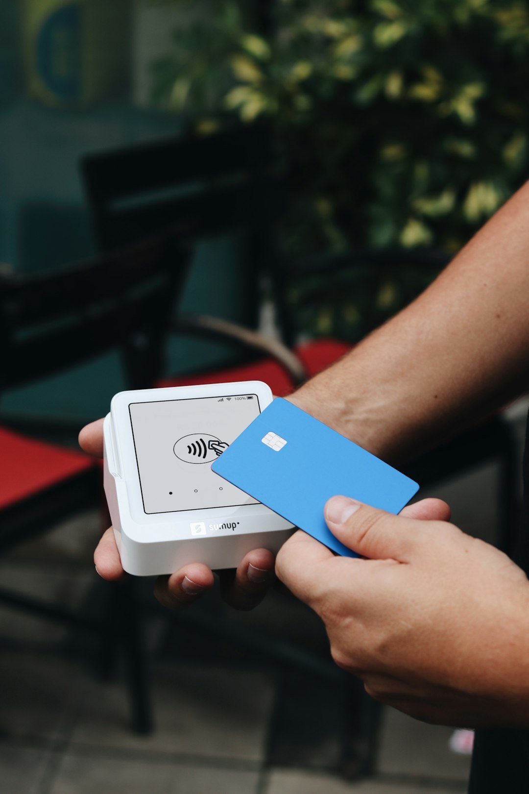 A person holding a white box with a blue card in it