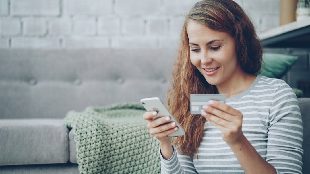 Woman using smartphone and credit card for online shopping