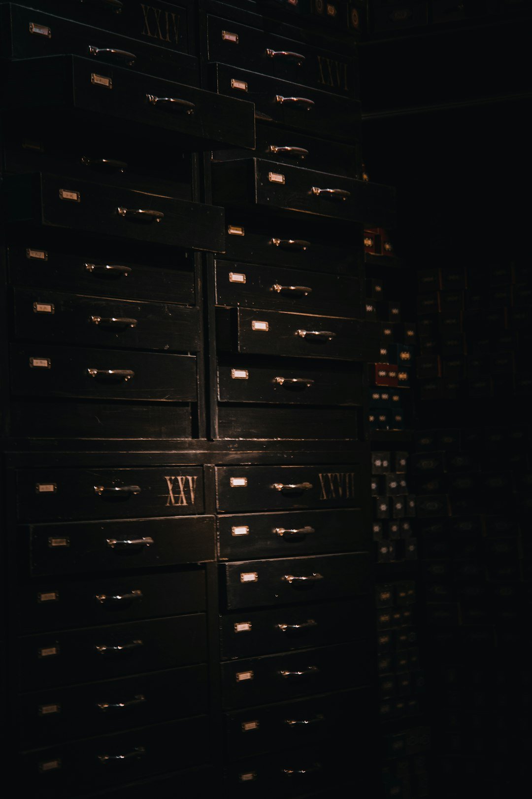 a large stack of drawers in a dark room