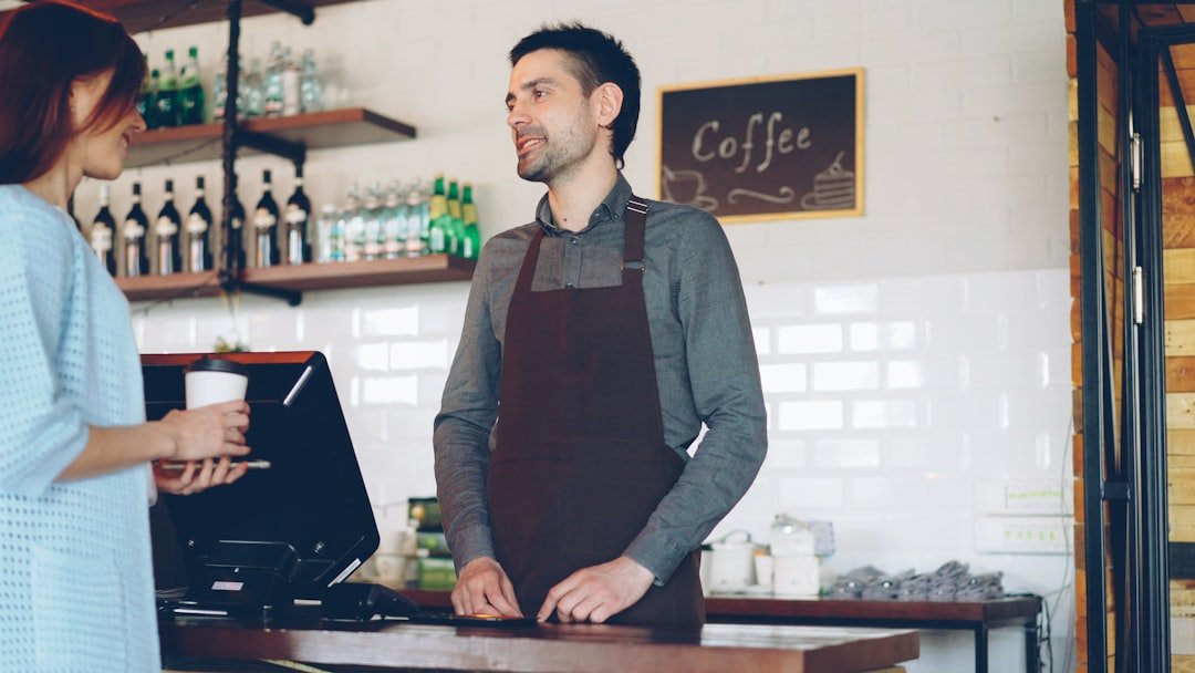 A barista is serving a customer coffee.